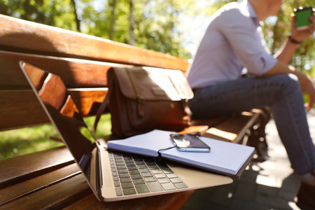 Man taking coffee break during work in park, focus on laptopの写真素材