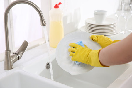 Woman washing plate in modern kitchen, closeupの写真素材