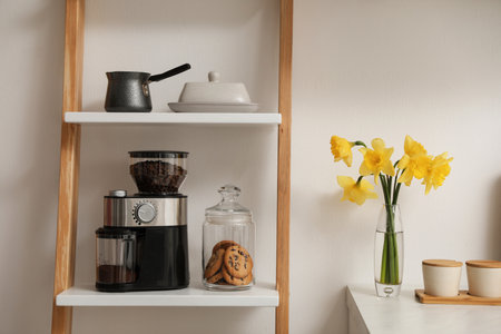Modern coffee grinder on shelving unit in kitchenの写真素材