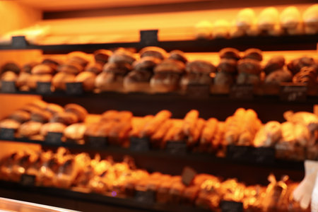 Blurred view of fresh pastries on counter in bakery store