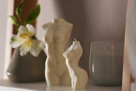 Beautiful body shaped candles and flower on shelfの写真素材