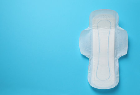 Sanitary napkin on light blue background, top view. Space for textの写真素材