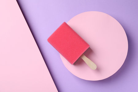 Sponge with wooden stick as ice cream on color background, top view. April Fools' Dayの写真素材