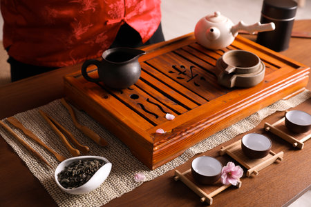 Traditional tea ceremony. Master at table with utensils, closeup. Tray with Chinese hieroglyph meaning Teaの写真素材