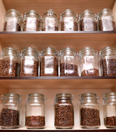 Glass jars with coffee beans on rackの写真素材