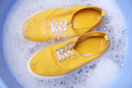 Washing sport shoes in plastic basin, top viewの写真素材