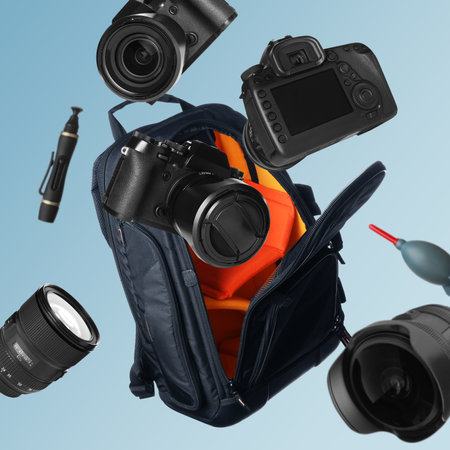 Different professional photography equipment falling on light blue backgroundの写真素材