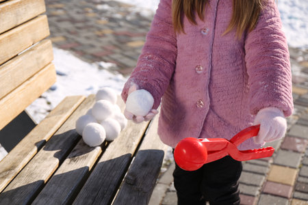 Little girl playing with snowball maker outdoors, closeupの写真素材