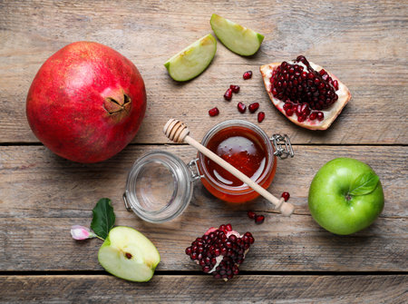 Honey, pomegranate and apples on wooden table, flat lay. Rosh Hashanah holidayの写真素材