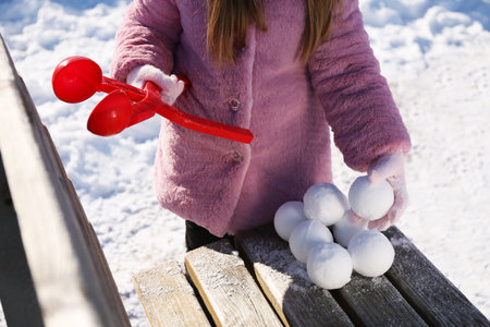 Little girl playing with snowball maker outdoors, closeupの写真素材
