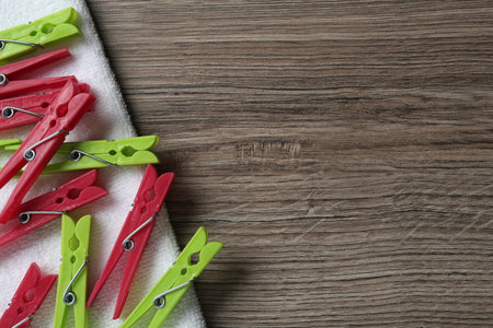 Colorful plastic clothespins and towel on wooden background, top view Space for textの写真素材