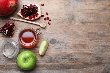 Honey, pomegranate and apples on wooden table, flat lay with space for text. Rosh Hashanah holidayの写真素材