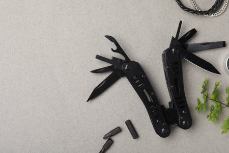 Compact portable multitool, details and bracelet on gray background, flat lay. Space for textの写真素材