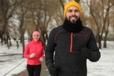Happy people running in winter park. outdoor sports exercisesの写真素材