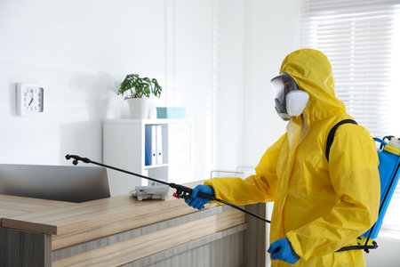 Employee in protective suit sanitizing office. medical disinfectionの写真素材