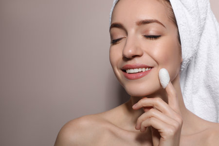 Woman using silkworm cocoon in skin care routine on light grey background. Space for textの写真素材