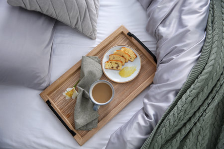 Aromatic coffee, biscuit and beautiful flower on bed with gray linens indoors, top viewの写真素材
