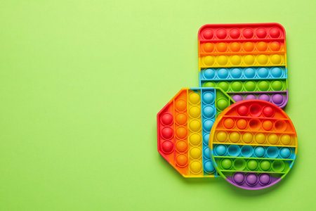 Rainbow pop it fidget toys on light green background, flat lay. Space for textの写真素材