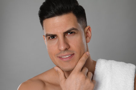 Handsome man after shaving on gray background, closeupの写真素材