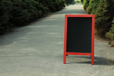 Blank advertising board on sidewalk in city. Mockup for designの写真素材