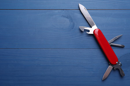 Modern compact portable multitool on blue wooden table, top view. Space for textの写真素材
