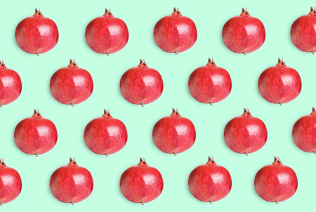 Delicious ripe pomegranates on turquoise background, flat layの写真素材