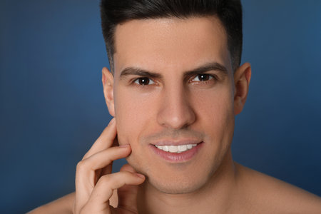 Handsome man after shaving on blue background, closeupの写真素材