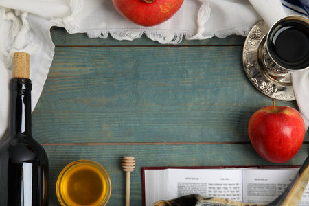 Frame of Rosh Hashanah holiday attributes on blue wooden table, flat lay. Space for textの写真素材