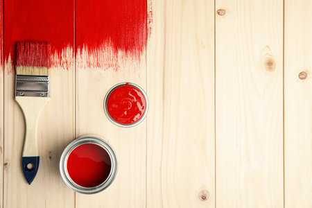 Brush and can of red dye on freshly painted wooden surface, flat lay. Space for textの写真素材