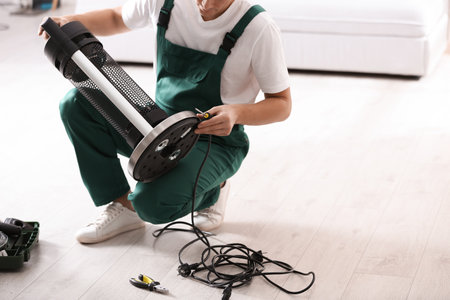 Professional technician repairing electric patio heater with screwdriver indoors, closeupの写真素材