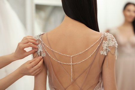 Woman trying on beautiful wedding dress in boutique, back viewの写真素材