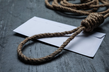 Rope noose and blank envelope on black table, closeupの写真素材