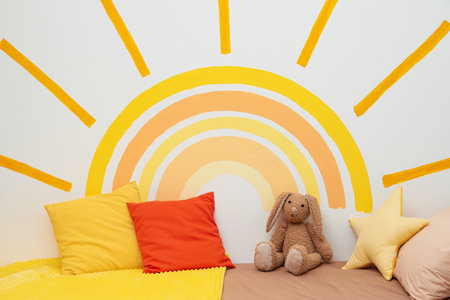 Cute child's room interior with beautiful sun painted on wallの写真素材