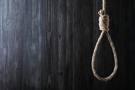 Tied rope noose against dark wooden background. Space for textの写真素材