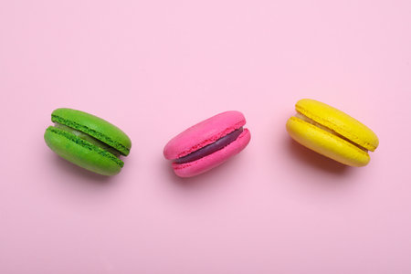 Delicious colorful macarons on pink background, flat layの写真素材