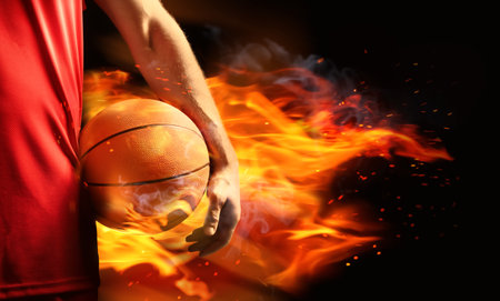 Basketball player with ball in flame on black background, closeupの写真素材