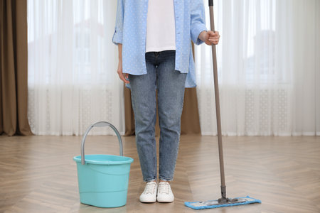 Woman with mop and bucket indoors, closeup. cleaning serviceの写真素材