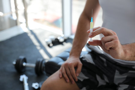 Sportsman with syringe in gym, closeup. Doping conceptの写真素材