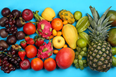 Assortment of fresh exotic fruits on light blue background, flat layの写真素材