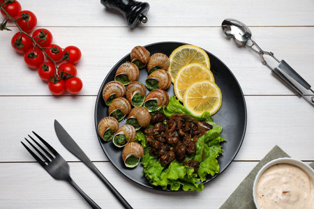 Delicious cooked snails served on white wooden table, flat layの写真素材