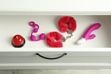 Different modern sex toys in open wooden drawer, above viewの写真素材