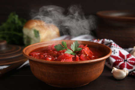 Stylish brown clay bowl with Ukrainian borsch served on wooden tableの写真素材
