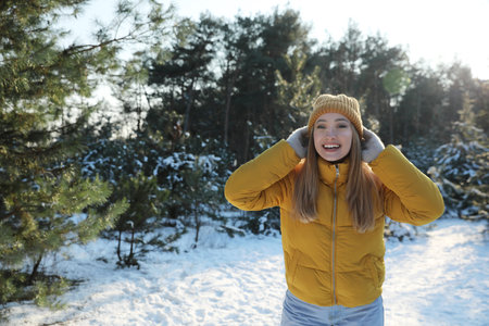 Woman enjoying winter day in forest, space for text