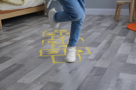 Little girl playing hopscotch at home, closeupの写真素材