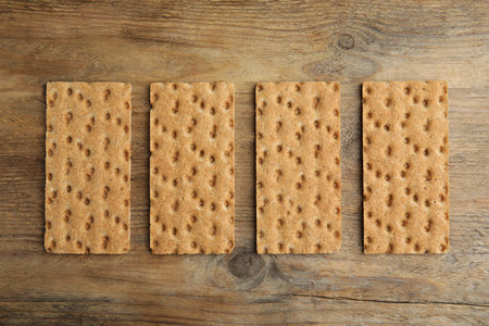 Fresh rye crispbreads on wooden table, flat layの写真素材