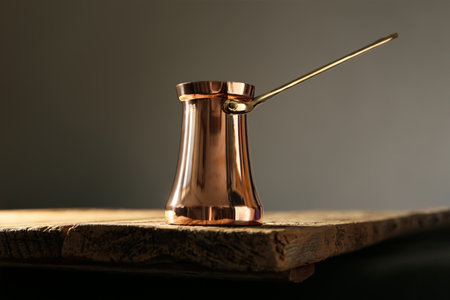 Beautiful copper turkish coffee pot on wooden tableの写真素材