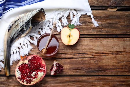 Honey, pomegranate, apples and shofar on wooden table, flat lay with space for text. Rosh Hashanah holidayの写真素材