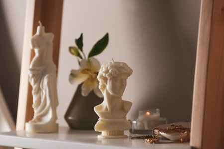 Beautiful David bust candle and jewelry on shelfの写真素材