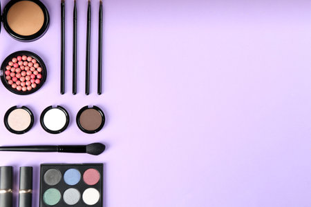 Flat lay composition with makeup brushes on violet background, space for textの写真素材