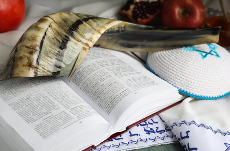 Traditional Rosh Hashanah holiday symbols on table, closeup. Book Torah and tallit with text in Hebrewの写真素材